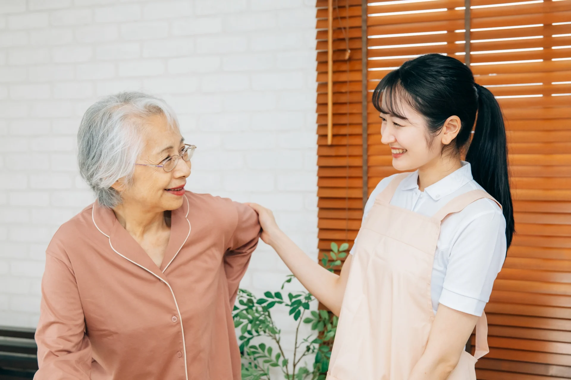 介護スタッフと高齢女性が在宅で向き合う様子